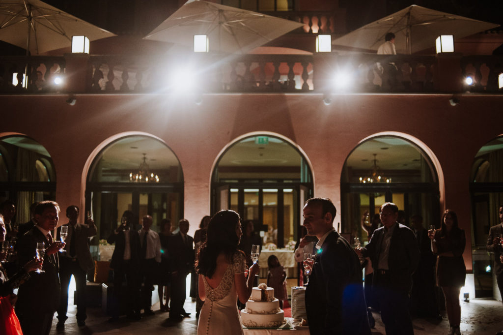 destination wedding cascais - couple cutting cake with wedding party
