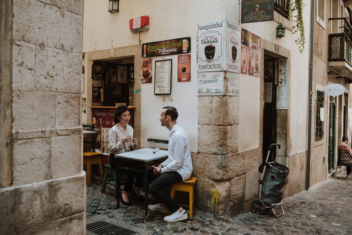 couple having ginginha at alfama - engagement photographer lisbon