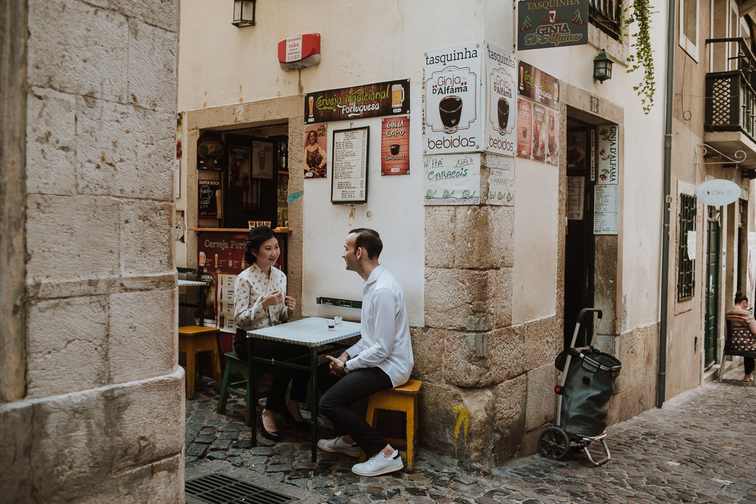 couple having ginginha at alfama - engagement photographer lisbon
